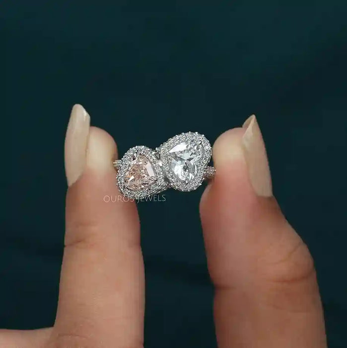 [ a women holding two heart diamond engagement ring]-[Ouros Jewels]