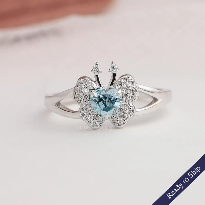 Blue heart cut butterfly shaped diamond engagement ring with cluster of round diamonds in 14k white gold