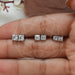[model holding pairs of princess diamond stud earrings]-[Ouros Jewels]