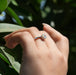 [a woman's hand wearing a solitaire diamond ring]-[Ouros Jewels]