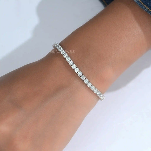 [a woman's wrist with a round diamond tennis bracelet]-[Ouros Jewels]