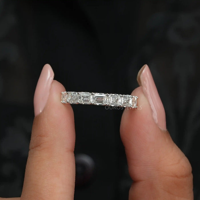 [A Women holding a seven stone emerald cut wedding ring]-[Ouros Jewels]