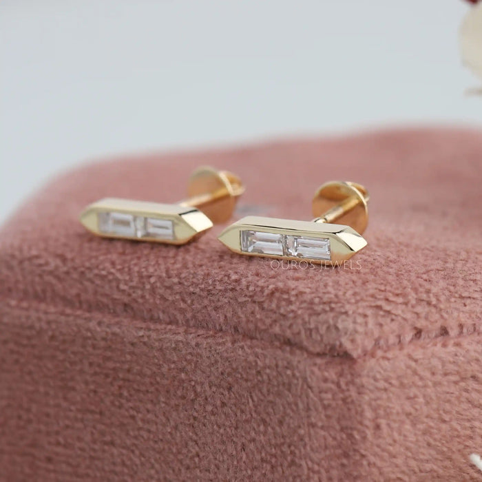 Bar stud earrings in solid yellow gold designed with baguette shaped diamonds