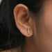 In ear front look of baguette diamond studs yellow gold