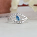 Close up view of pear shaped diamond engagement  ring with blue pear diamond & round small diamonds.