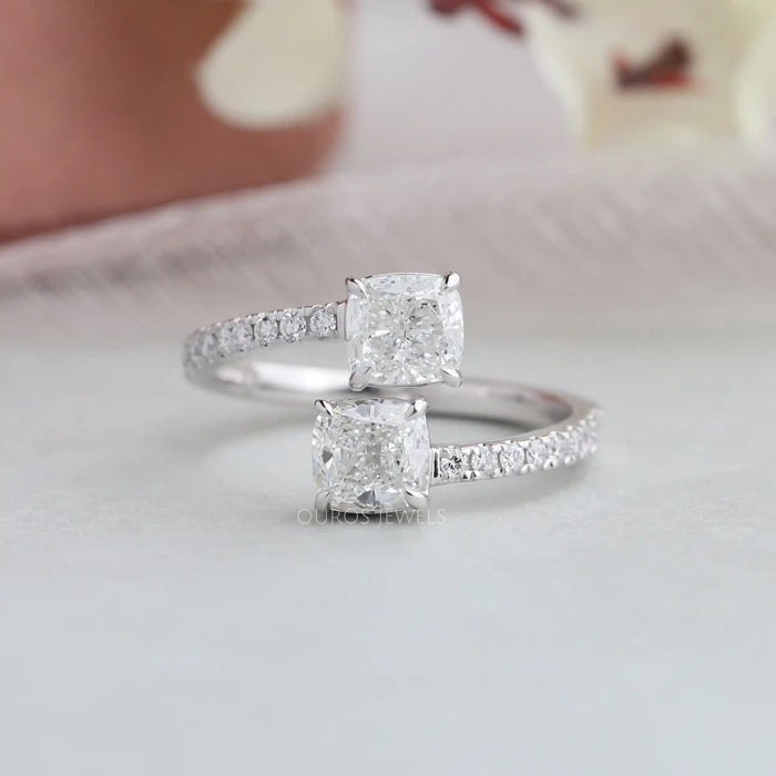 Cushion cut lab made diamond bypass set engagement ring with claw prongs and round accent stones