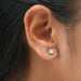 In ear look of cushion cut lab created diamond solitaire stud earrings with claw prongs in white gold