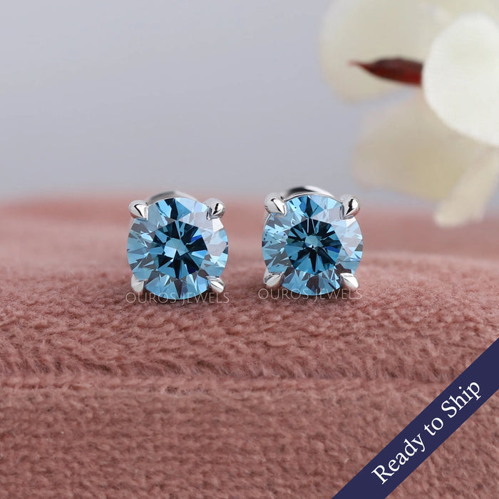 Blue round brilliant cut lab grown diamond solitaire earrings with claw progs in 14k white gold