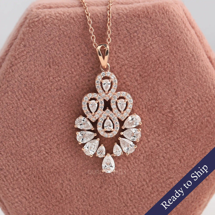 Flower shaped diamond pendant with pear cut lab grown diamond and halo of round diamonds crafted in 14k rose gold