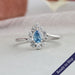 Blue oval shaped lab grown diamond engagement ring with a halo of round diamonds crafted in 14k white gold
