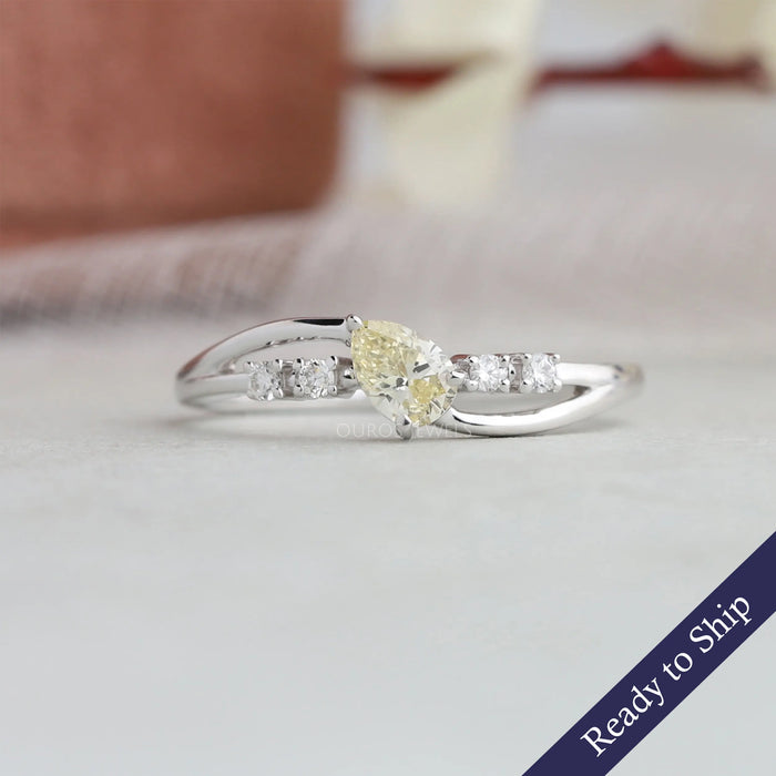 Yellow pear cut diamond engagement ring curved bypass shank studded with round diamonds in 14k white gold