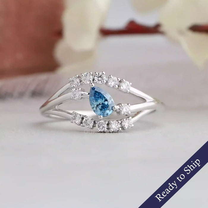 This alluring pear shaped diamond ring set in bypass style with Blue color &  VS Clarity.