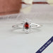 Red oval shaped lab grown diamond engagement ring with halo of round diamonds in 14k white gold