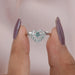 Two finger front view of lab made cushion cut diamond made of green color with half halo settting.