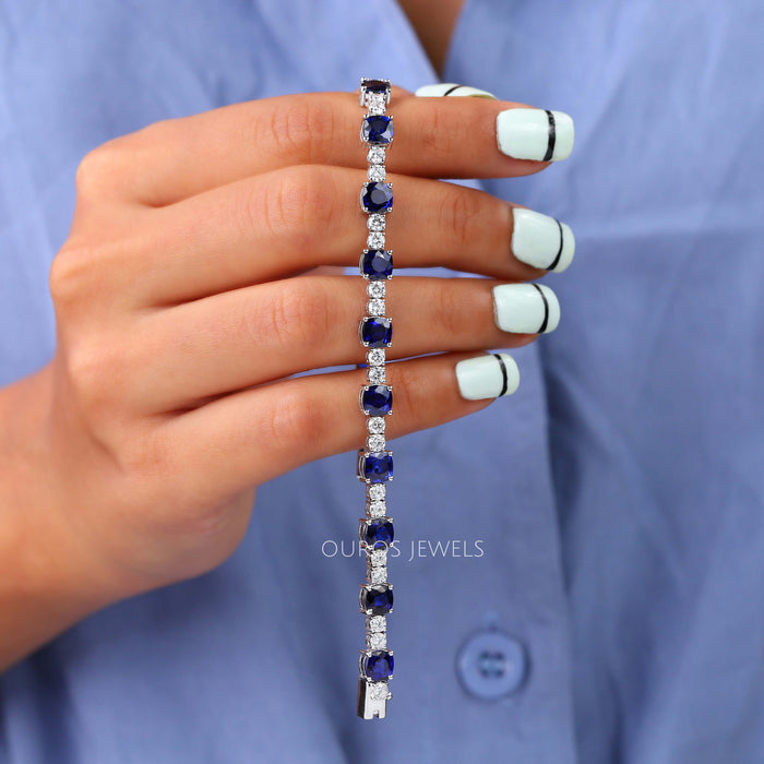 [A Women Holding Blue Cushion Cut Lab Diamond Bracelet]-[Ouros Jewels]