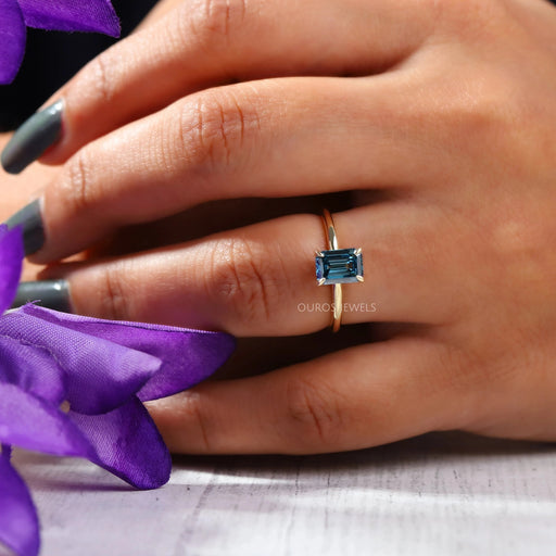 An Emerald Cut Blue Ring In Finger With Stunning Brilliance