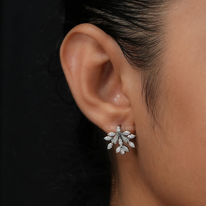 In ear front look of pear and round lab made diamond earrings