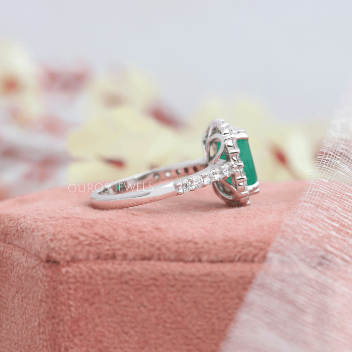 The emerald cut of the gemstones, paired with the halo setting, creates a timeless and classic look that will never go out of style