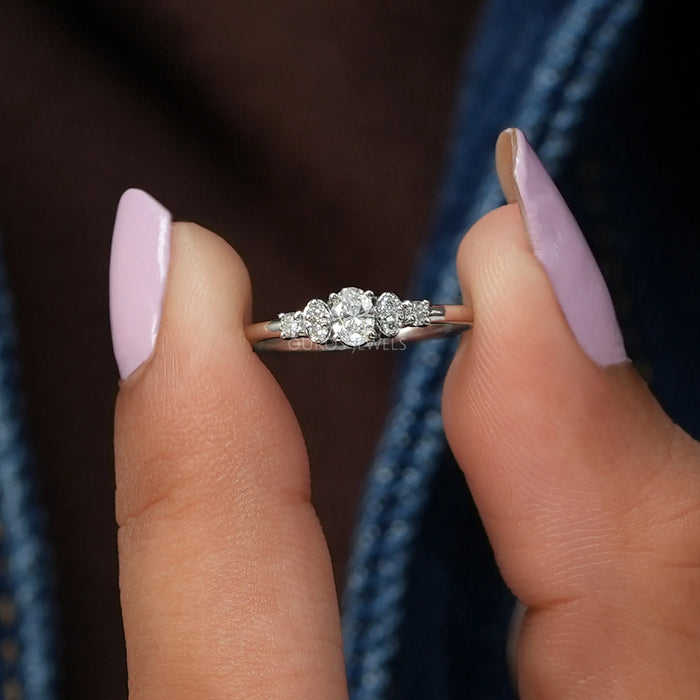 In finger front view of  cluster lab diamond Dainty engagement ring with oval cut diamond