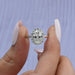 A close up look of oval shaped solitaire engagement ring surrounded by halo of round diamonds