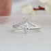 Engagement ring features a pear-shaped diamond as the centerpiece, complemented by smaller diamonds that are expertly arranged in a curved band