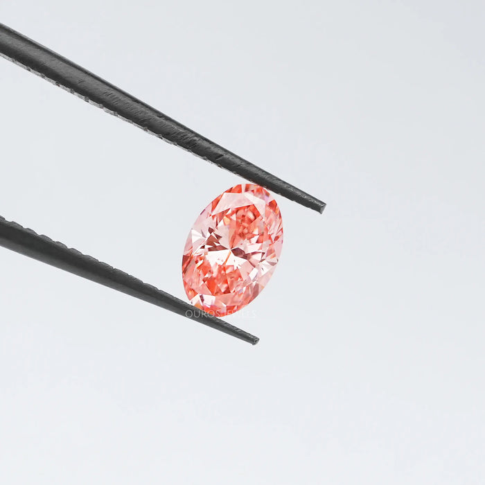 Pink oval cut loose lab manufactured diamond in tweezer