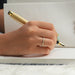 [A Women writing in a book wearing Round Diamond Eternity Wedding Band]-[Ouros Jewels]