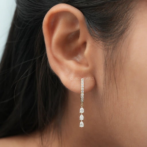 In ear appearance of swaying drop and dangle earrings made with pear and round cut lab created diamonds