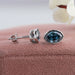 Side view of oval blue stud earrings set in bezel, crafted with 14k white gold.