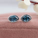 Close up view of step cut blue oval diamond earrings made of 14k white gold & VS clarity.