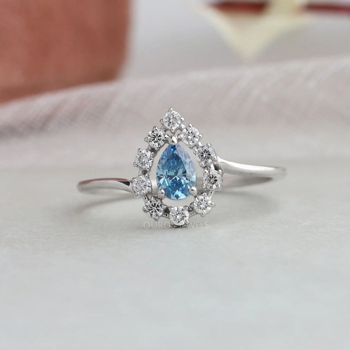 The Blue Pear Cut Halo Diamond Ring is a stunning piece of jewelry, crafted with exceptional design