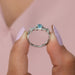 Infinity style diamond wedding ring with blue colored radiant diamond