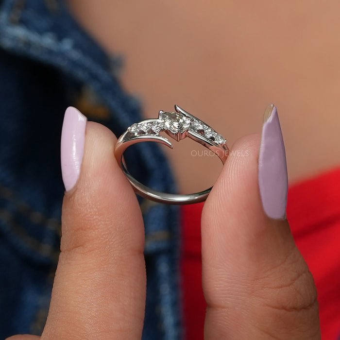 In two finger front view of pear shaped diamond ring set in bypass with 4k white gold.