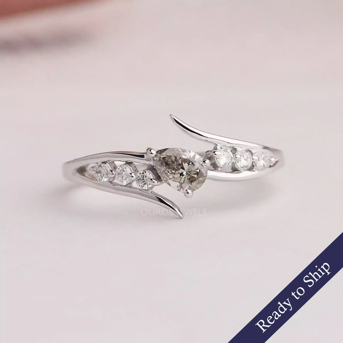 Front view of pear shape diamond bypass ring center stone olive color with 14k white gold. 