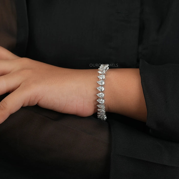 A white gold colorless pear shaped diamond tennis bracelet with VS clarity.