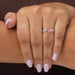 In finger front view of oval cut diamond engagement ring crafted with 4 prongs, this ring set in bypass & VS clarity.