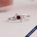 Red cushion cut cluster diamond ring made of 4k white gold with round cut diamonds.