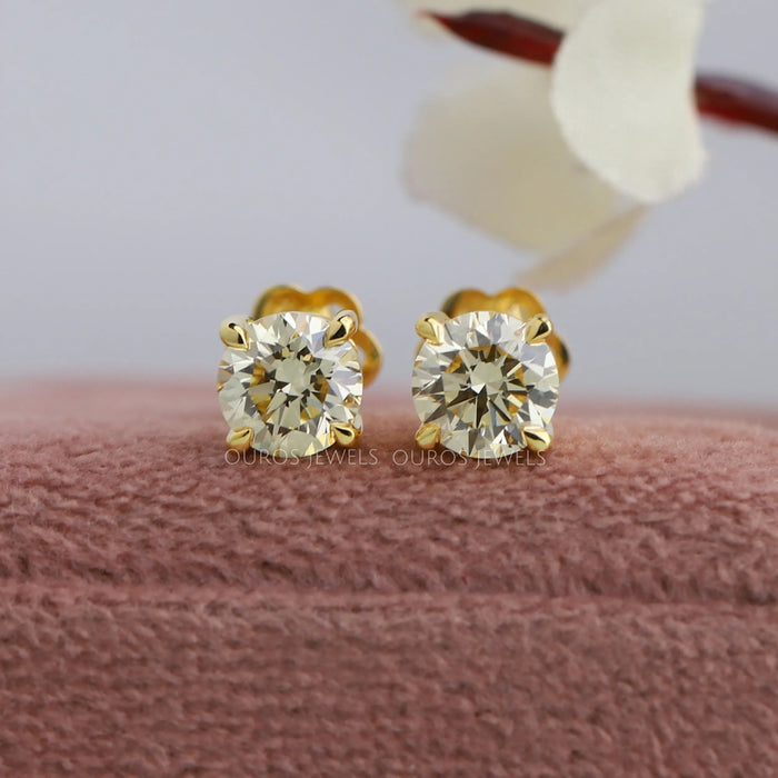 VS clarity round brilliant cut diamond stud earrings with four claw prongs in yellow gold