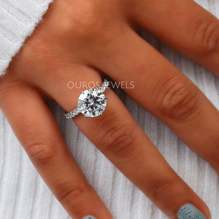 In finger look of brilliant cut solitaire engagement ring with small round accent stones