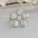 A close up look of round and yellow pear cut diamond engagement ring with a glittering flower shaped design