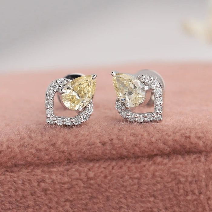 Yellow pear cut lab diamond stud earrings with heart shaped halo of round diamonds