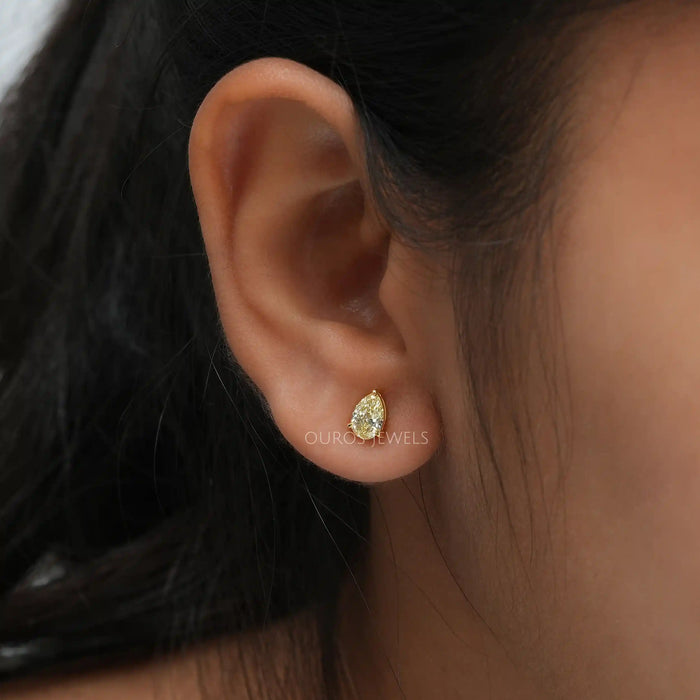 In ear look of yellow pear lab created diamond solitaire earrings