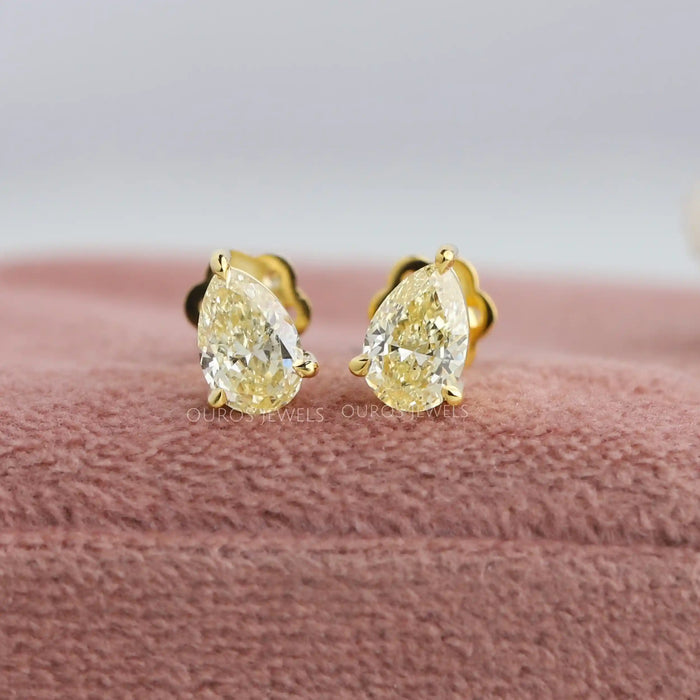 A pair of yellow pear brilliant cut earrings with 3 claw prongs setting